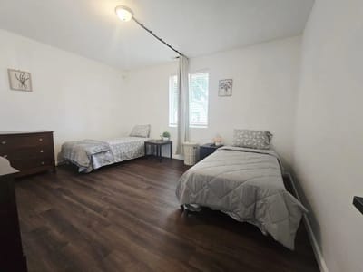 A shared resident room with two beds and a dresser