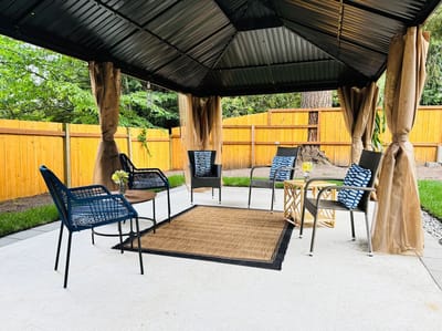 Outdoor seating area with chairs and a table under a gazebo