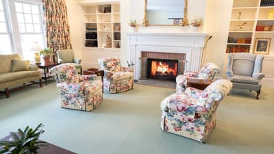 Cozy lounge area with floral chairs and fireplace