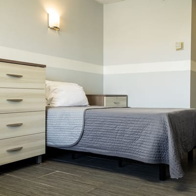 Private resident room with a bed and dresser