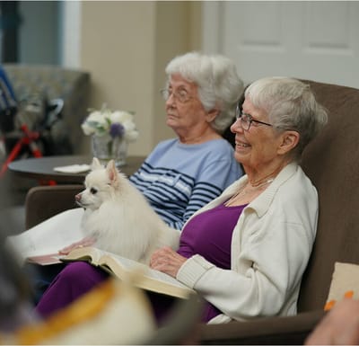 Residents enjoying an indoor gathering with a small dog