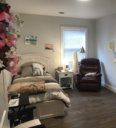 Cozy private resident room with a bed and chair