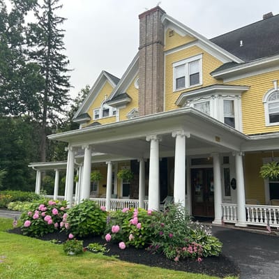 Exterior view of The Athenaeum of Skaneateles with flowers