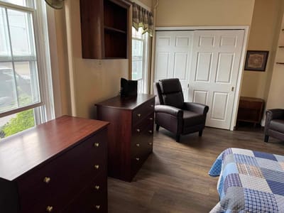 Cozy private room with a bed and armchair