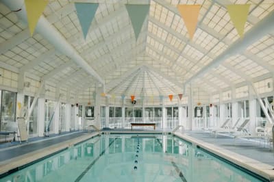 Indoor pool area with seating and bright decor