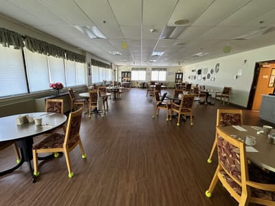 Dining room with tables and chairs set for residents