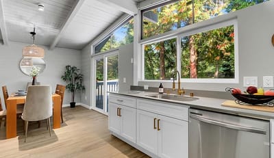 Bright kitchen area with large windows and dining table