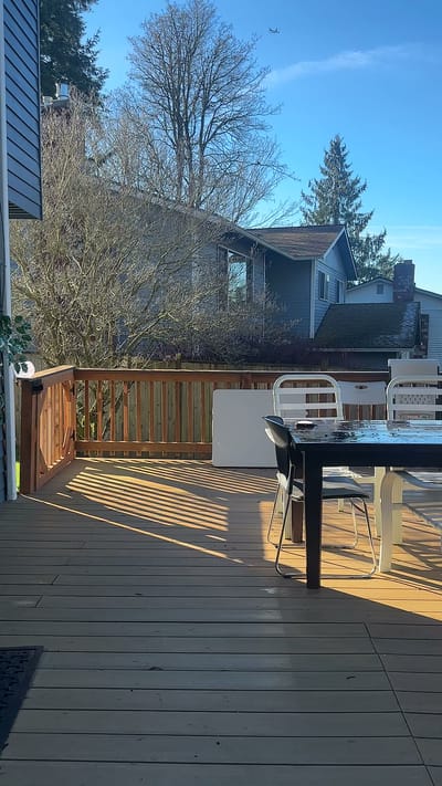 Wooden patio area with chairs and sunlight