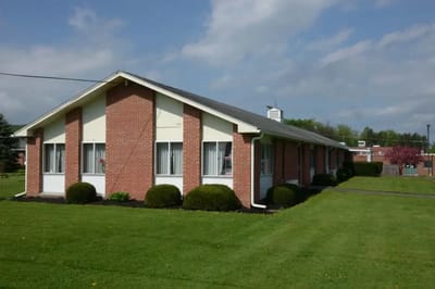 Exterior view of the assisted living facility surrounded by greenery