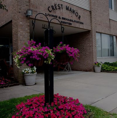 Entrance of Crest Manor with flowering plants