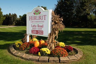 Facility sign with vibrant flowers and pumpkins