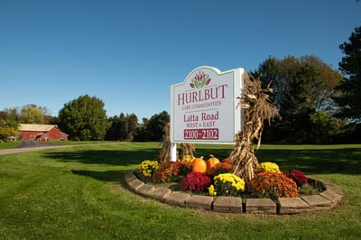 Sign for Latta Road Nursing Home East amidst flowers
