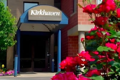 Entrance of Kirkhaven surrounded by blooming flowers