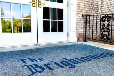 Entrance doors of The Brightonian with welcome mat