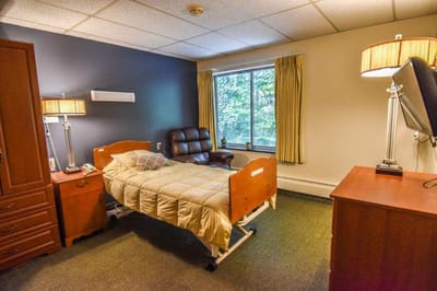 Private resident room with a bed and armchair