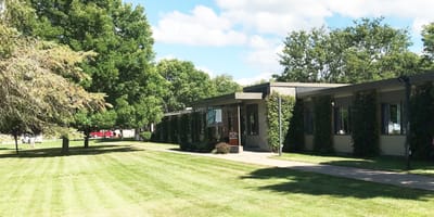 Exterior view of a senior care facility surrounded by trees