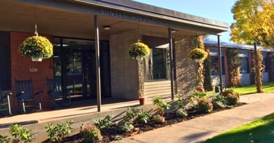 Exterior view of Sunset Nursing Home with flower pots