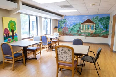 A bright common area with tables and mural