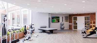 Well-equipped fitness room with exercise equipment and large windows