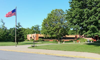 Exterior view of Slate Valley Center with flag and trees