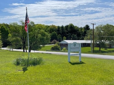 Exterior view of the facility sign with surrounding landscape.