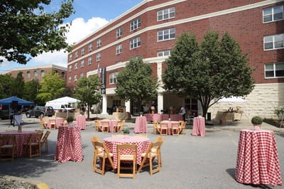 Outdoor courtyard setup for a gathering with tables and tents