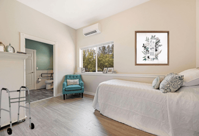 Bright resident room with a bed and seating area