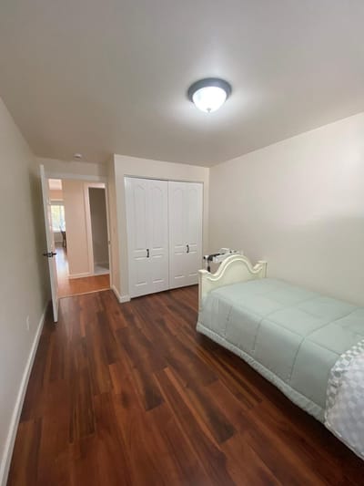 A simple, well-lit private bedroom in the facility