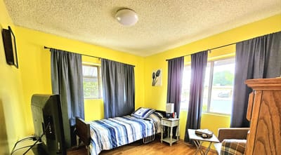 A cozy resident room with yellow walls and a bed