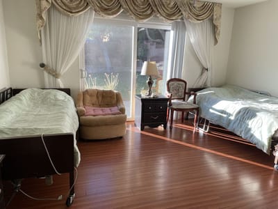 Well-lit interior room with two beds and furnishings