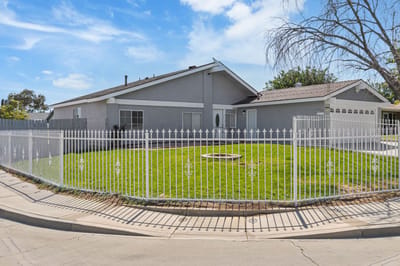 Exterior view of a senior living facility with a fence and lawn