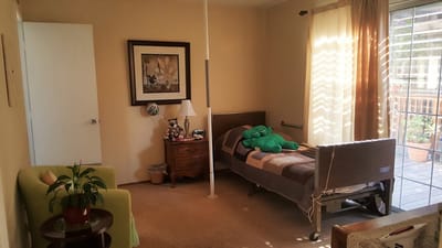 A cozy resident room featuring a bed and sitting area