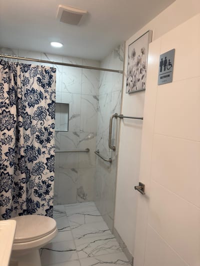 A clean bathroom with a shower and safety features