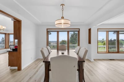 Bright dining area with large windows and a wooden table