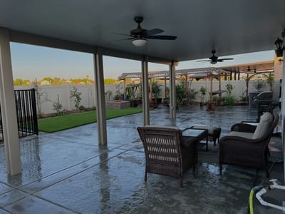 Covered outdoor patio with seating and greenery