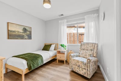 Cozy bedroom with a single bed and floral chair
