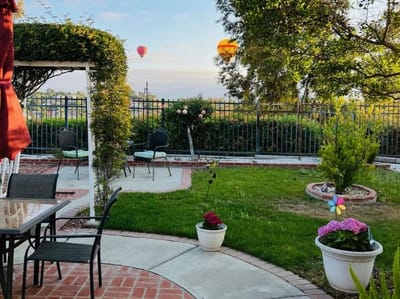 A tranquil garden area with seating and hot air balloons