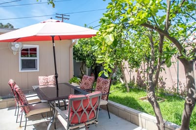 Outdoor patio seating area with umbrella and greenery
