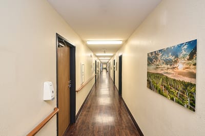 A hallway in a senior living facility with art on the wall