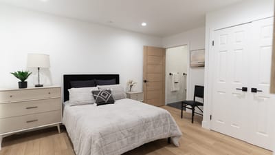 Bright and modern resident room with a bed and dresser