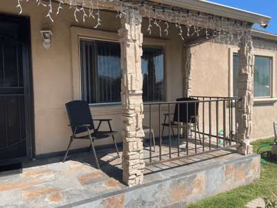 Outdoor porch area with chairs and stone facade