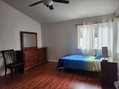 A private resident room with a bed and dresser