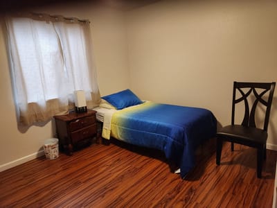 A single bedroom with a bed and chair