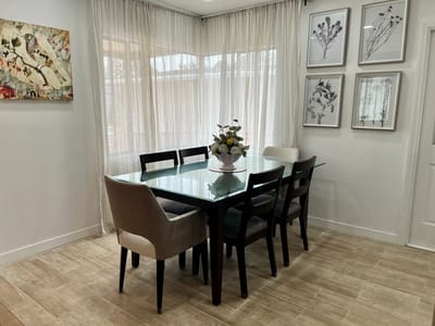 Bright dining room with a large table and flower arrangement