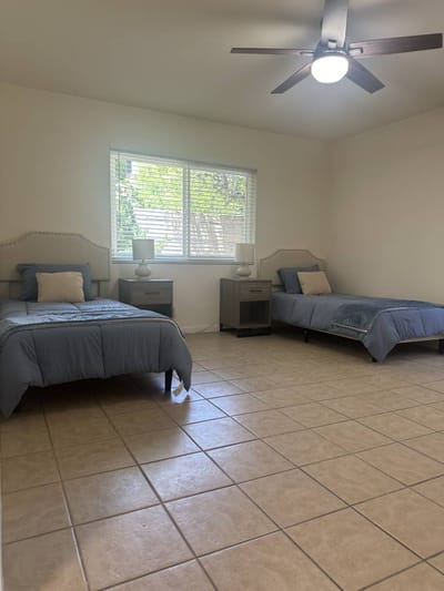 A well-lit shared bedroom with two beds