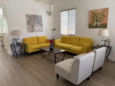 Bright common area with yellow sofas and artwork