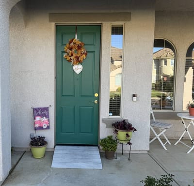 Exterior view of a welcoming green door with decor