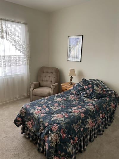 Cozy bedroom with floral bedding and armchair