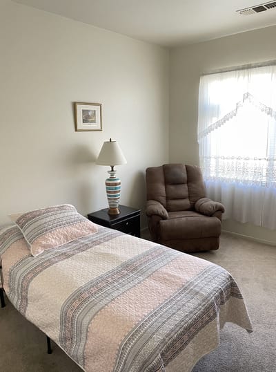 Cozy private resident room with a bed and chair
