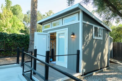 Exterior view of a small building with open doors.